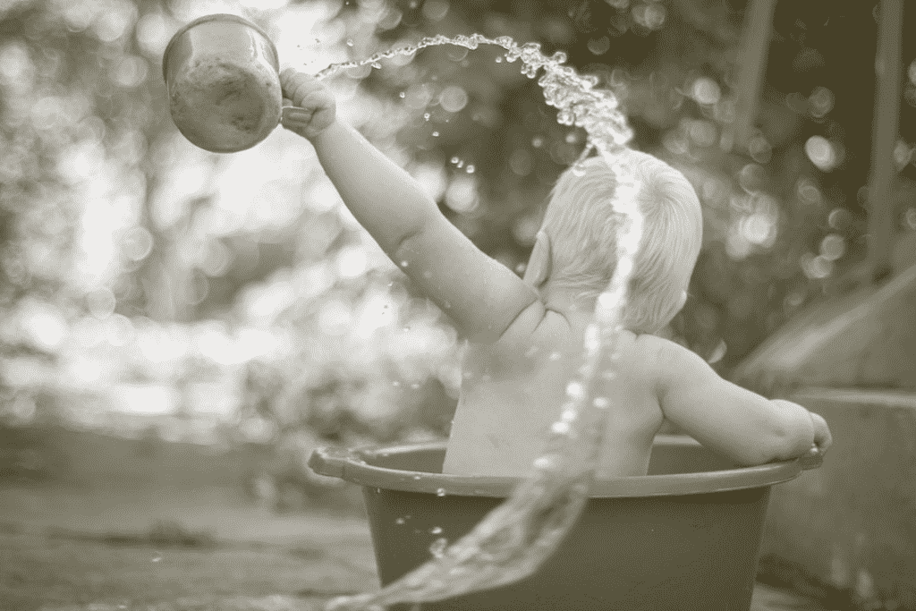 Baby taking bath in bucket