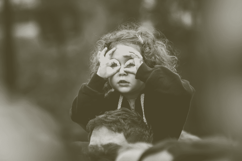 Small child on adults shoulders focusing
