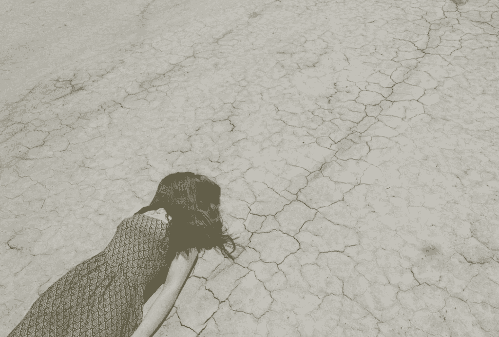 Person laying out cracked ground that has been impacted by a drought