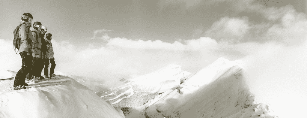 Skiers the top of a mountain, avalanche preparedness