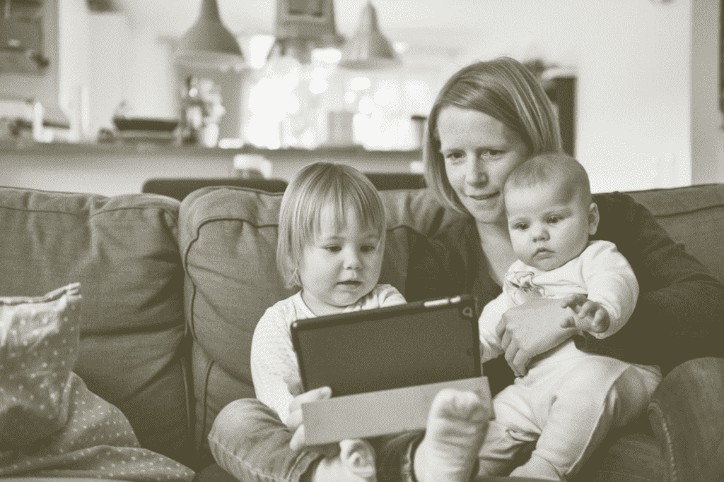 Mom and her infant and toddler watching a movie on iPad